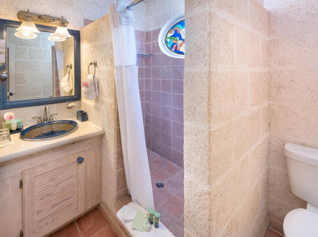 a bathroom with a shower and a sink and a toilet at Little Arches Boutique Hotel - Adults Only in Christ Church