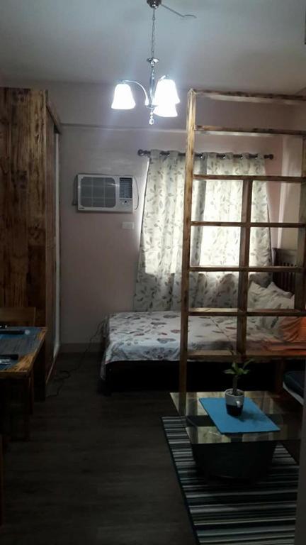 a bedroom with a bunk bed and a table at The Treehouse A @ Trees Residences in Manila
