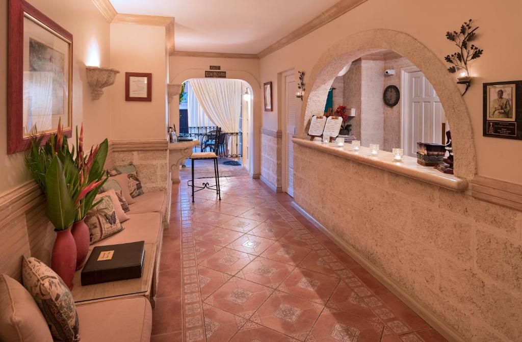 a living room with a couch and a mirror at Little Arches Boutique Hotel - Adults Only in Christ Church