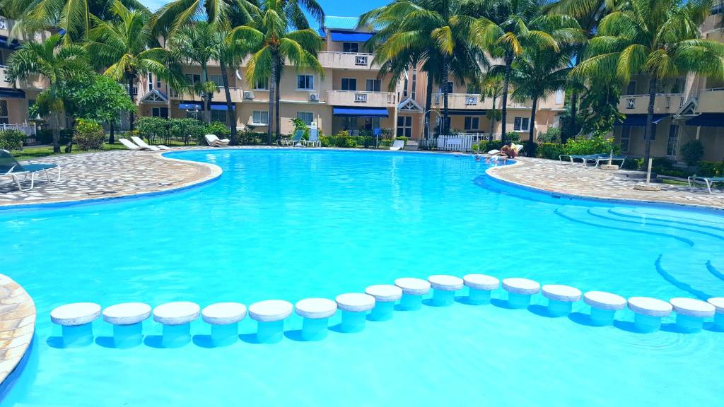 una piscina en un complejo con palmeras en Résidence Le Dattier, 2 bedrooms apartment, Flic en Flac, en Flic en Flac