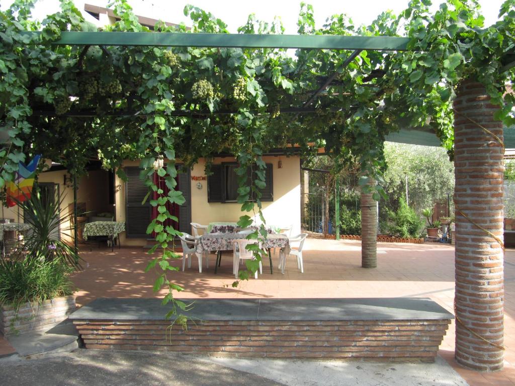 een pergola met een tafel en stoelen eronder bij Cottage in the green in Misterbianco