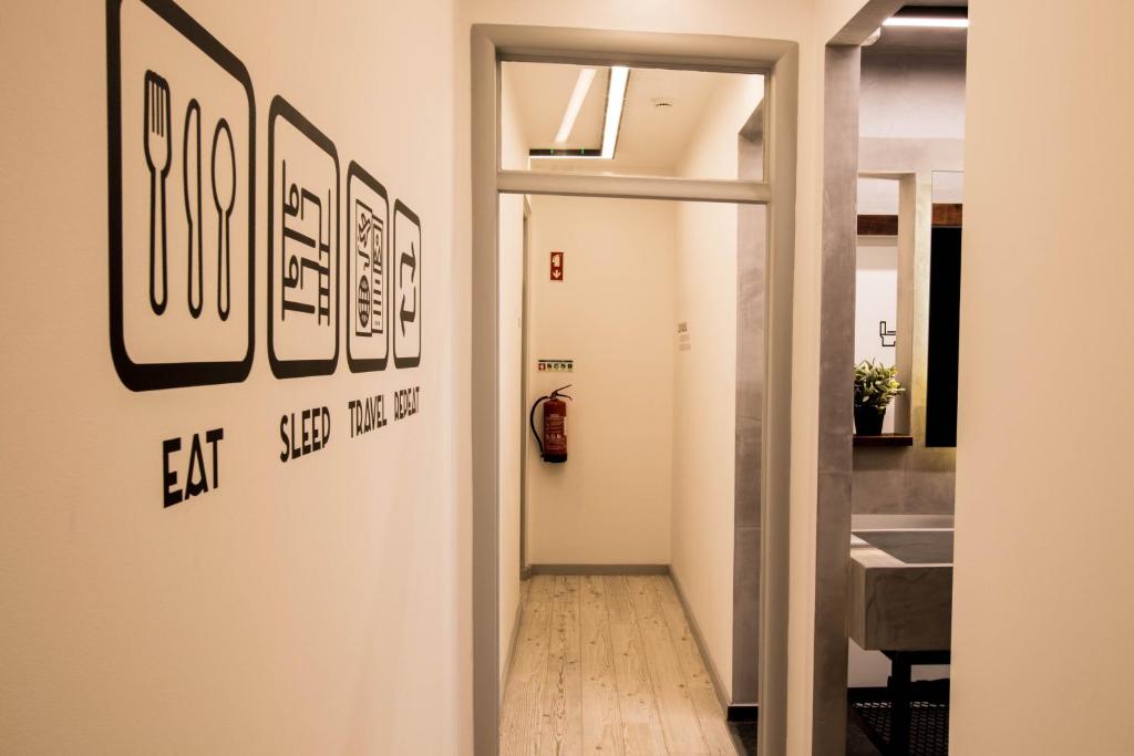 a hallway with a door with pictures on the wall at GiG Capsule Hostel in Ericeira