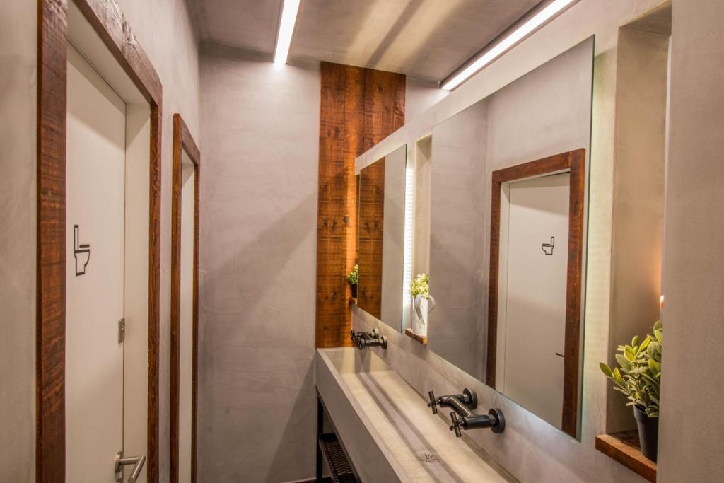 a bathroom with a sink and a mirror at GiG Capsule Hostel in Ericeira