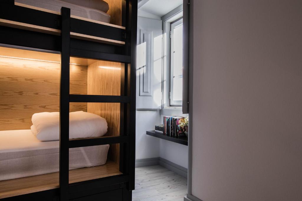 a bedroom with bunk beds and a window at GiG Capsule Hostel in Ericeira