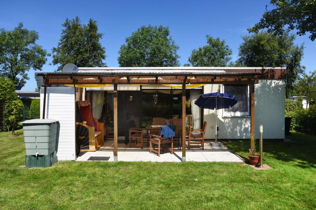 班薩席耶的住宿－Ferienhaus Duenenrose，一个带桌子和雨伞的小棚子