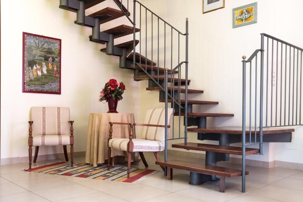 una escalera en una sala de estar con 2 sillas y una mesa en Il Mulino en Guardiagrele