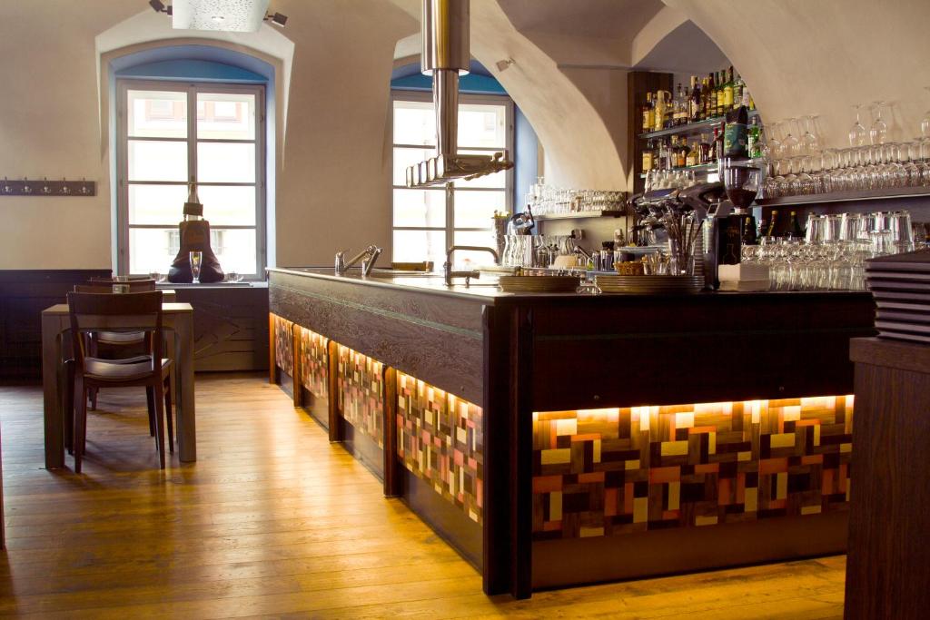 a bar in a restaurant with a counter and chairs at Zelena Ratolest in České Budějovice