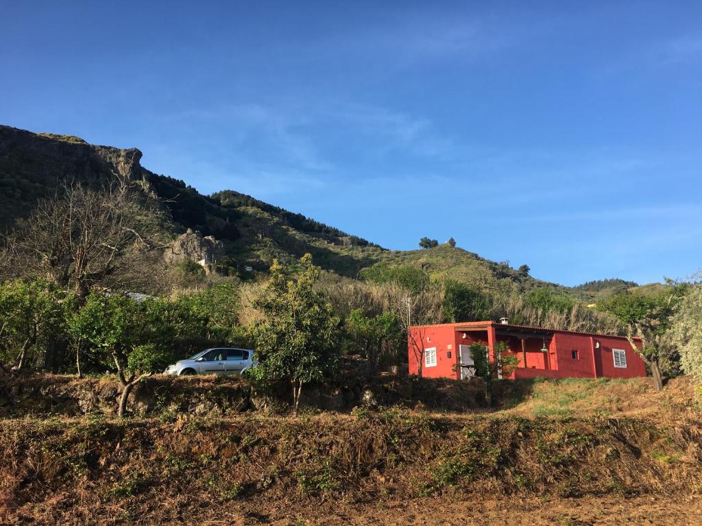 a car parked next to a red trailer on a hill at Villa Rafael in Vega de San Mateo