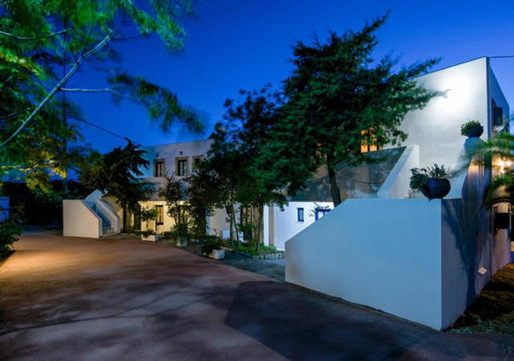 a house with a white wall in front of a driveway at Contaratos Holiday Lettings in Kýthira