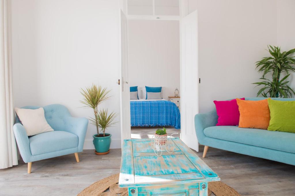 uma sala de estar com duas cadeiras azuis e uma mesa em Dream Residence em Olhão
