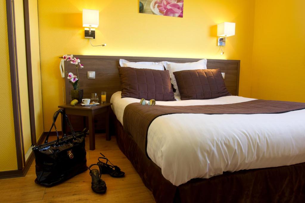 una habitación de hotel con una cama grande y una mesa en Logis Auberge De La Dune - Hôtel & Restaurant, en Le Crotoy