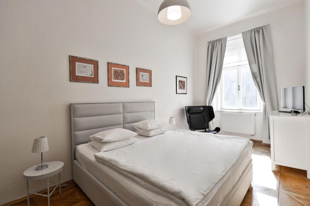 Postel nebo postele na pokoji v ubytování Kafka's Head Apartment