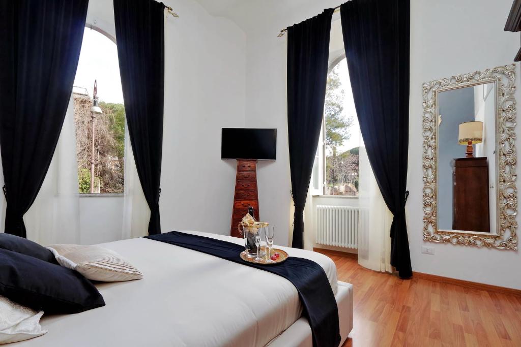 a bedroom with a bed with black curtains and a mirror at Dolce Casa Colosseo in Rome