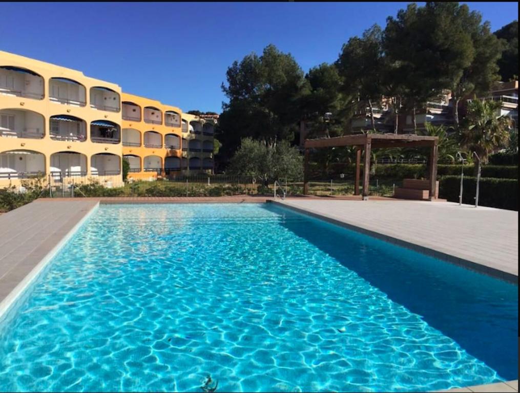 a swimming pool in front of a building at Calipso Tamarit in Tarragona