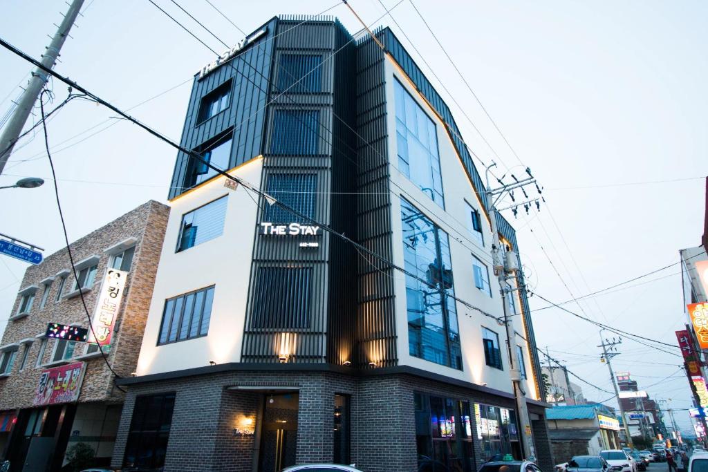 un grand bâtiment avec un panneau à l'avant dans l'établissement Yeosu Thestay Hostel, à Yeosu