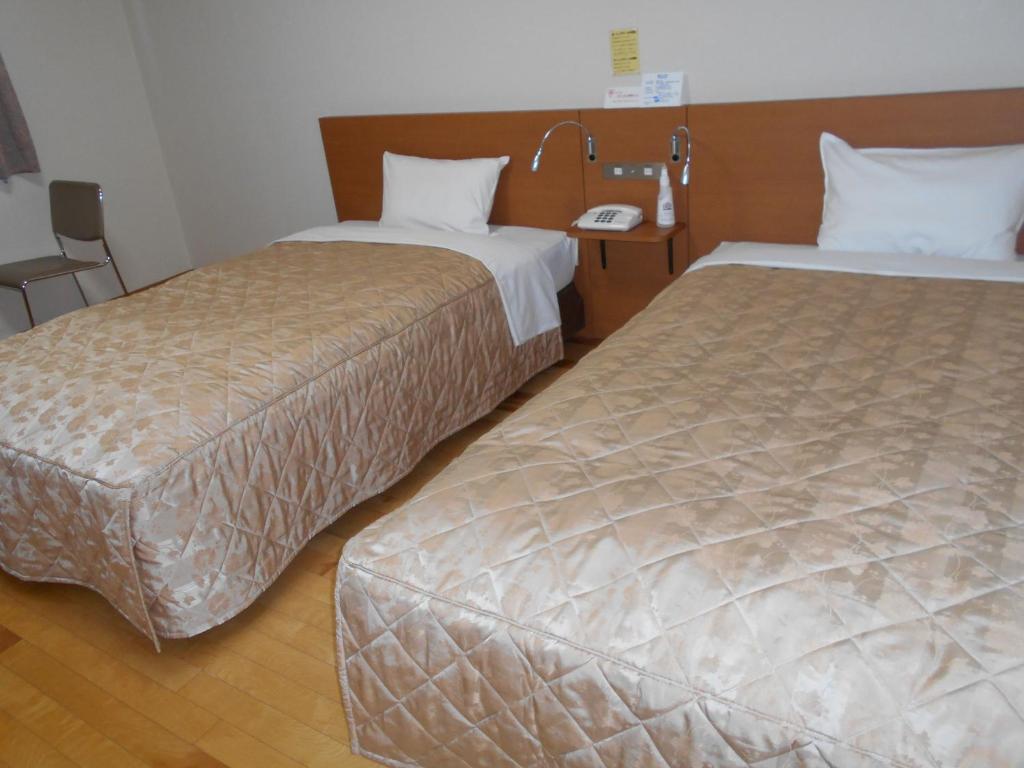 Postel nebo postele na pokoji v ubytování New Central Hotel Katsuta