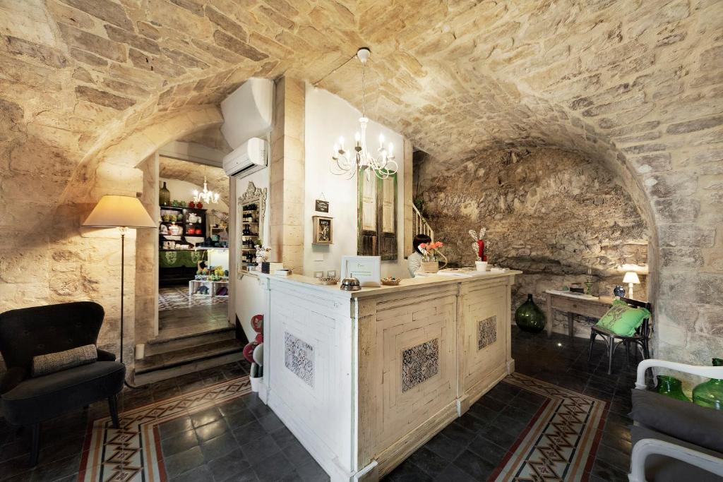 una stanza con un muro in pietra e un bancone in una stanza di Sabbinirica a Ragusa