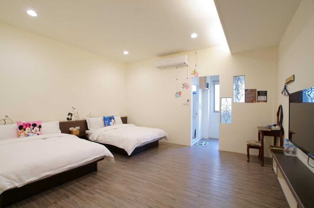 a bedroom with two beds and a tv in it at Jamie home stay in Taitung City