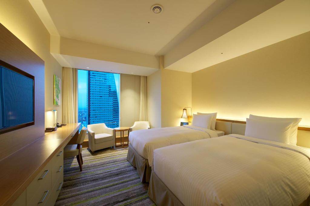 名古屋市にある名古屋JRゲートタワーホテルのベッド2台、薄型テレビが備わるホテルルームです。