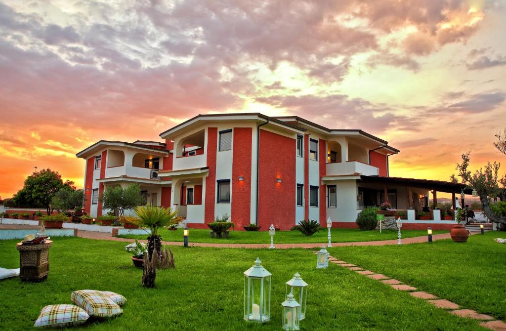 a house with a lawn in front of a sunset at Residence Garden in Sellia Marina
