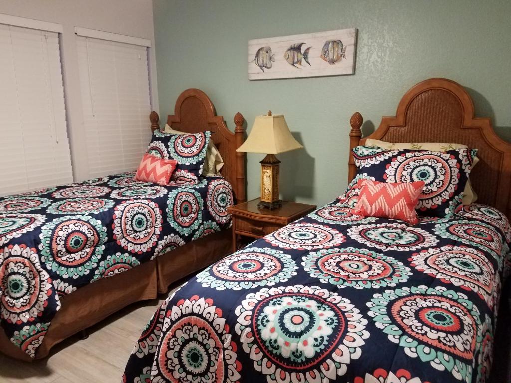 1 dormitorio con 2 camas y mesa con lámpara en 2BR/1BA Sienna Park Apartment, en Sarasota