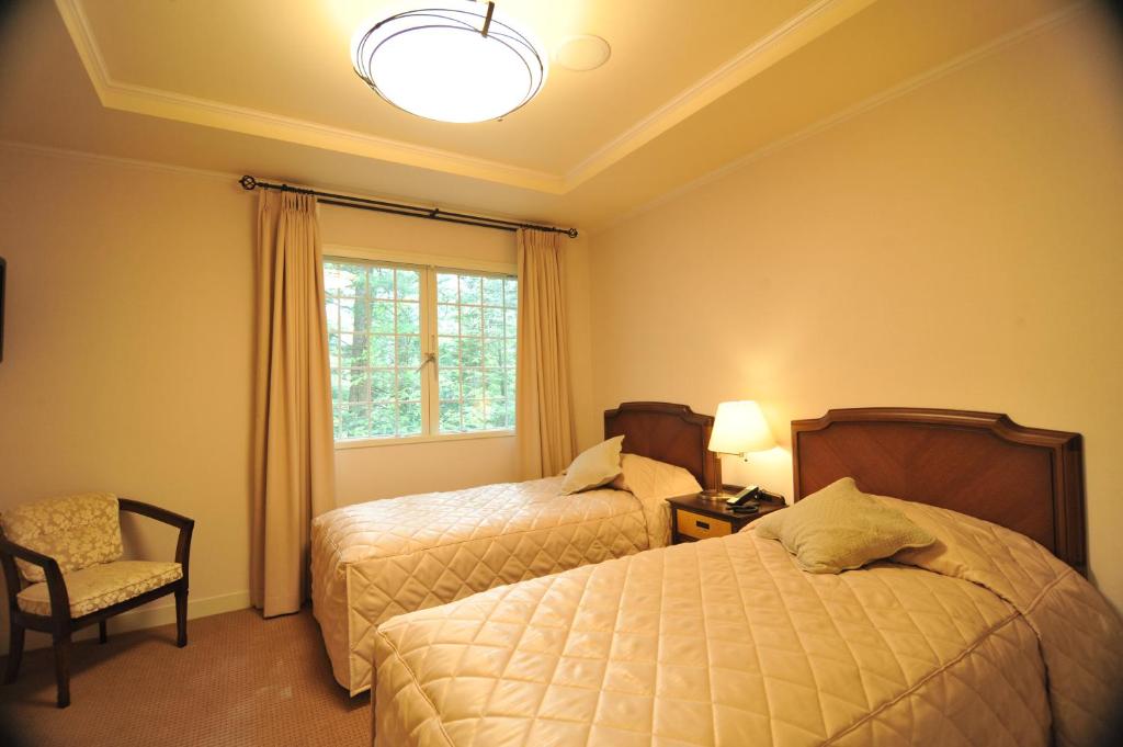 Postel nebo postele na pokoji v ubytování Kyu Karuizawa Hotel Otowa No Mori