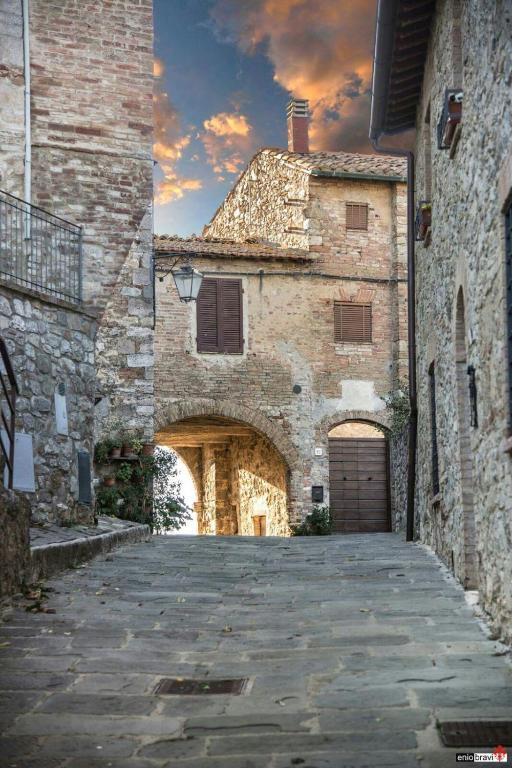 duży kamienny budynek z łukiem i garażem w obiekcie Casa Costanza w mieście Castiglione dʼOrcia