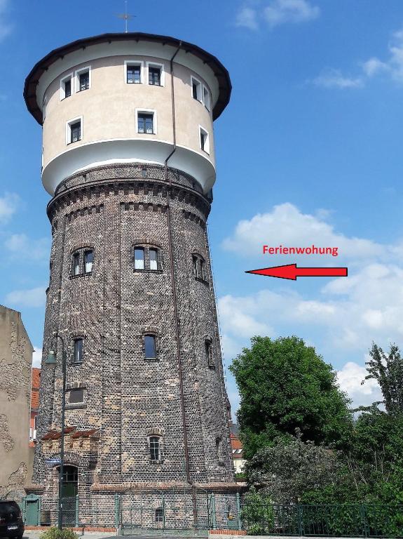 a tall brick tower with a red arrow on it at Wasserturm Angermünde in Angermünde
