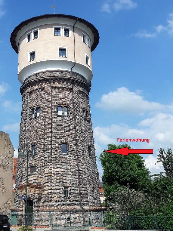 a tall brick tower with a red arrow on it at Wasserturm Angermünde in Angermünde