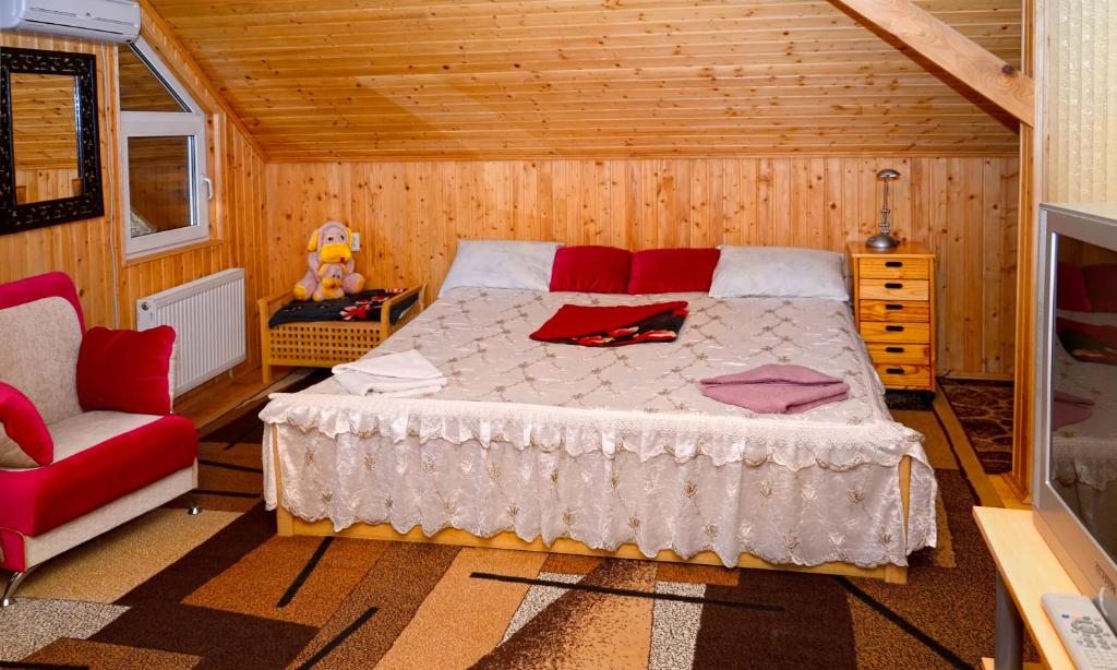 a bedroom with a bed and a red chair at Perlyna Podillyа in Satanov