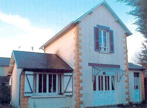 una pequeña casa blanca con una ventana y una puerta en Gite les Flots Bleus, en Jullouville-les-Pins