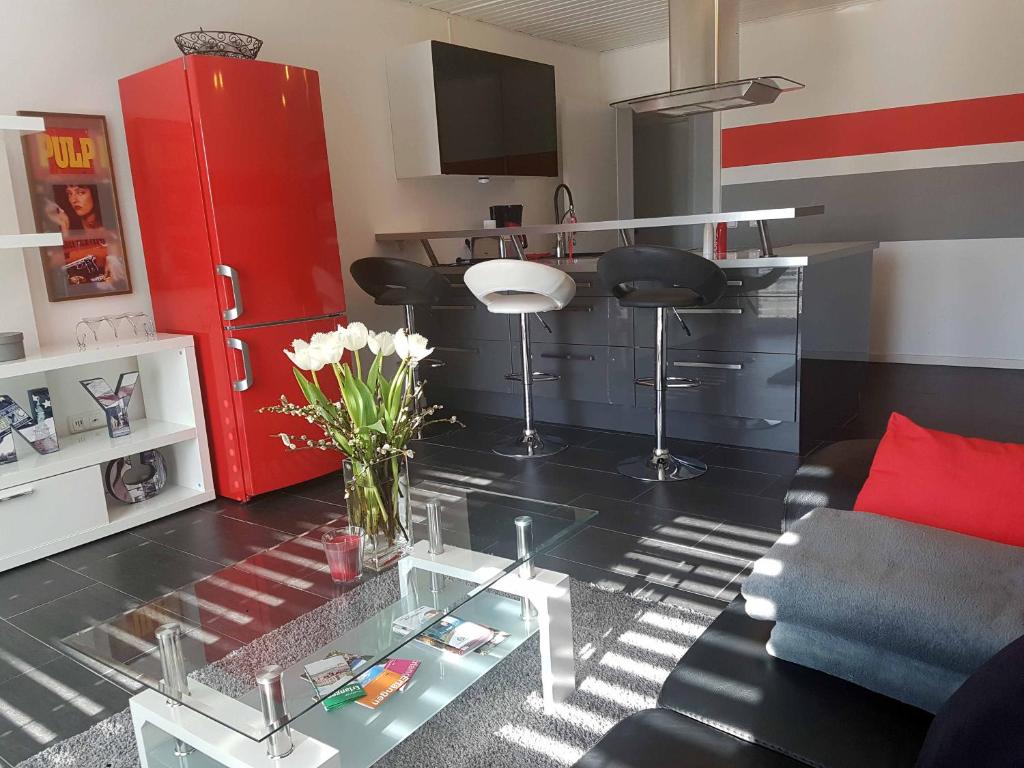 ein Wohnzimmer mit einem roten Kühlschrank und einem Tisch in der Unterkunft Häuslinger Ferienwohnung in Erlangen