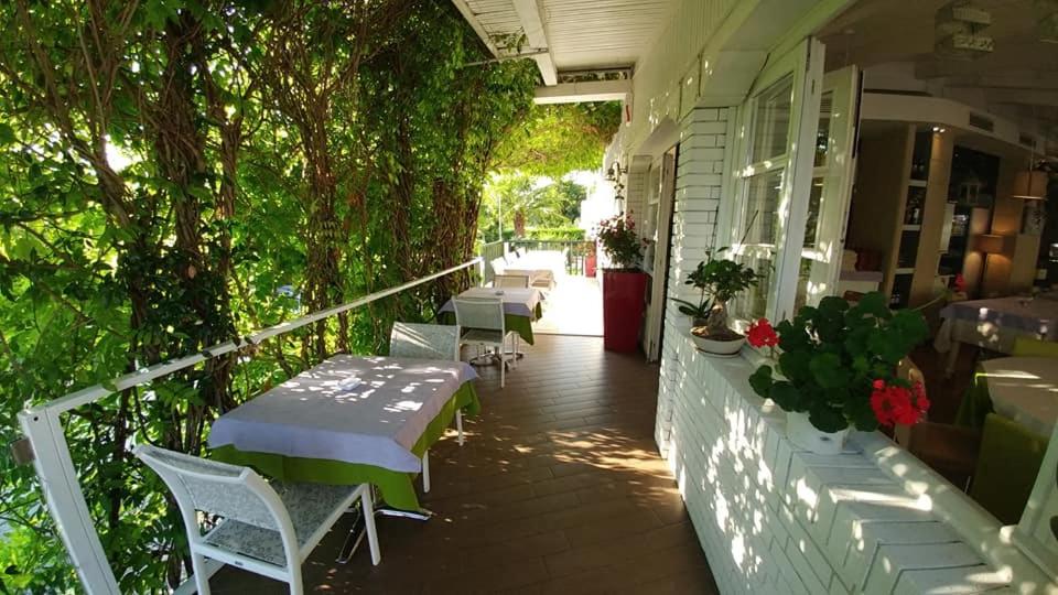 a porch with tables and chairs on a building at Hotel Ristorante Fortuna in Cavallino-Treporti