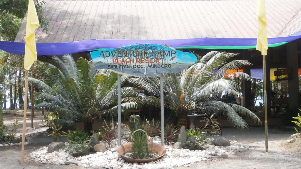 una sombrilla frente a un edificio con plantas en Adventure Camp Beach Resort, en Sablayan