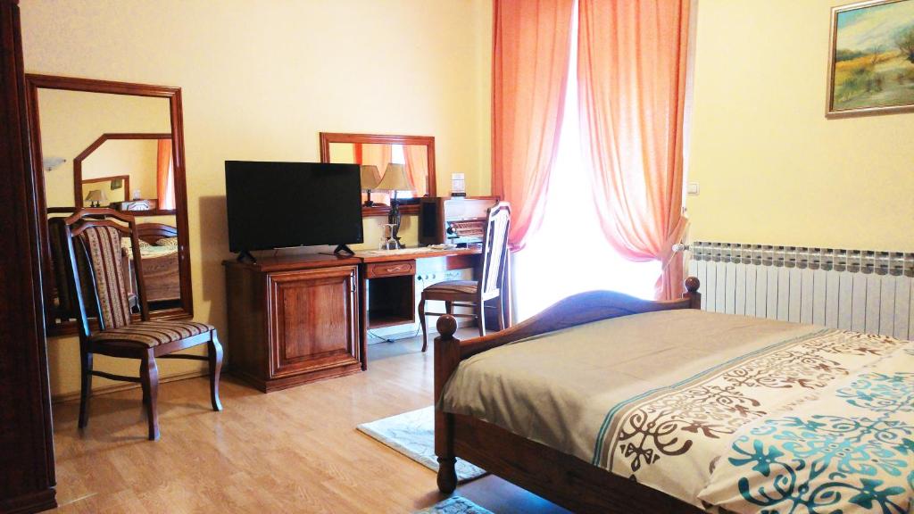 1 dormitorio con 1 cama y escritorio con TV en Hotel Derby Orašje, en Orašje