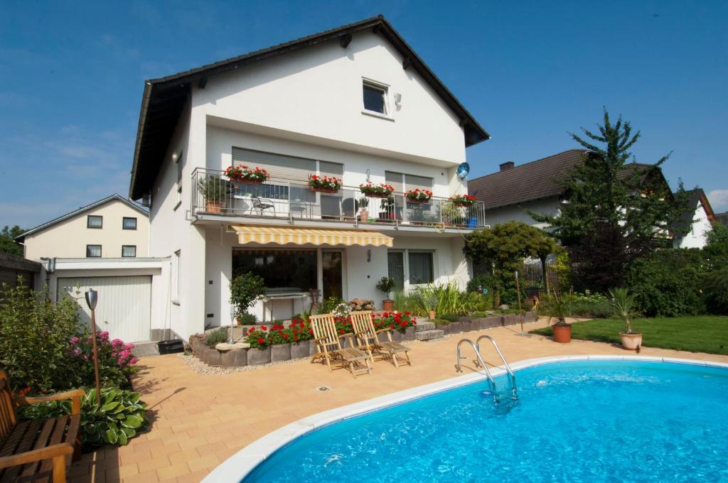 une maison avec une piscine en face de celle-ci dans l'établissement FeWo-Schwarzer, à Ingelheim-sur-le-Rhin