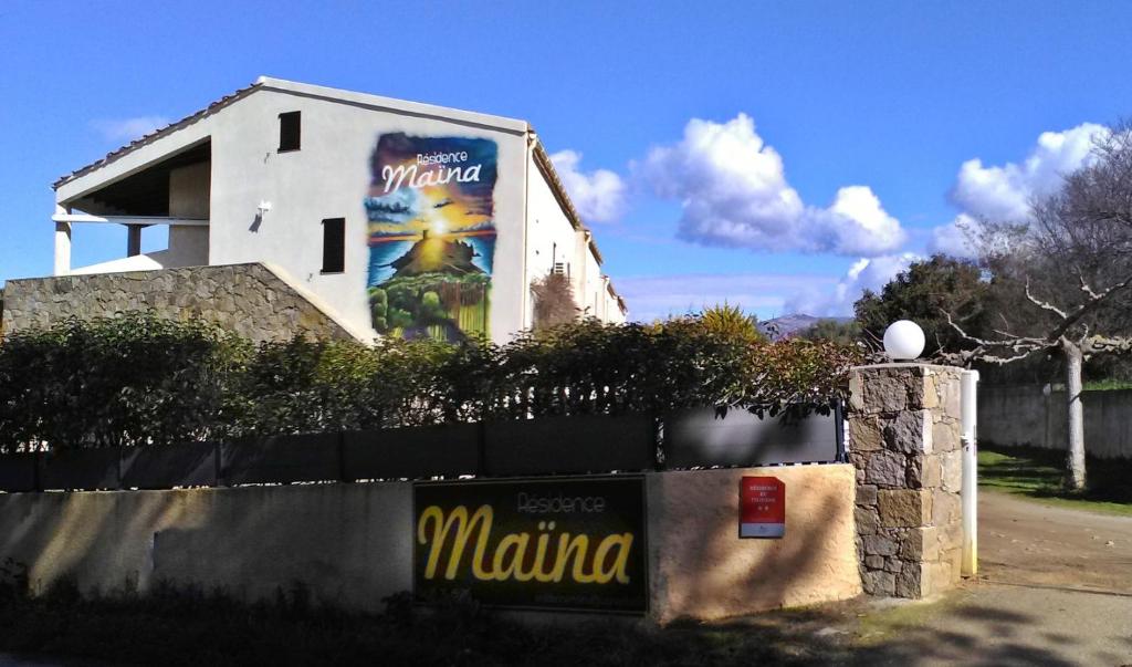 um edifício com um grande cartaz ao lado em Residence Maïna em Cargèse