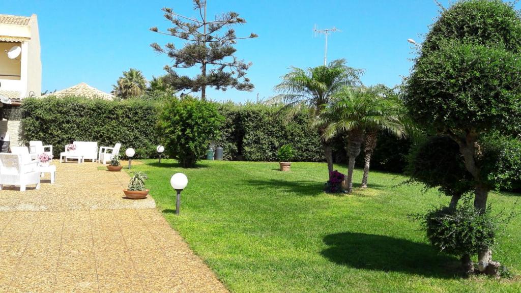 a garden with trees and chairs on a lawn at Villa Margherita in Marsala