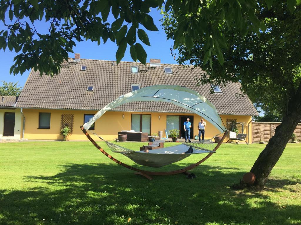 a hammock in a yard in front of a house at Ferienwohnungen "Weitblick" und "Schwalbennest" in Lodmannshagen