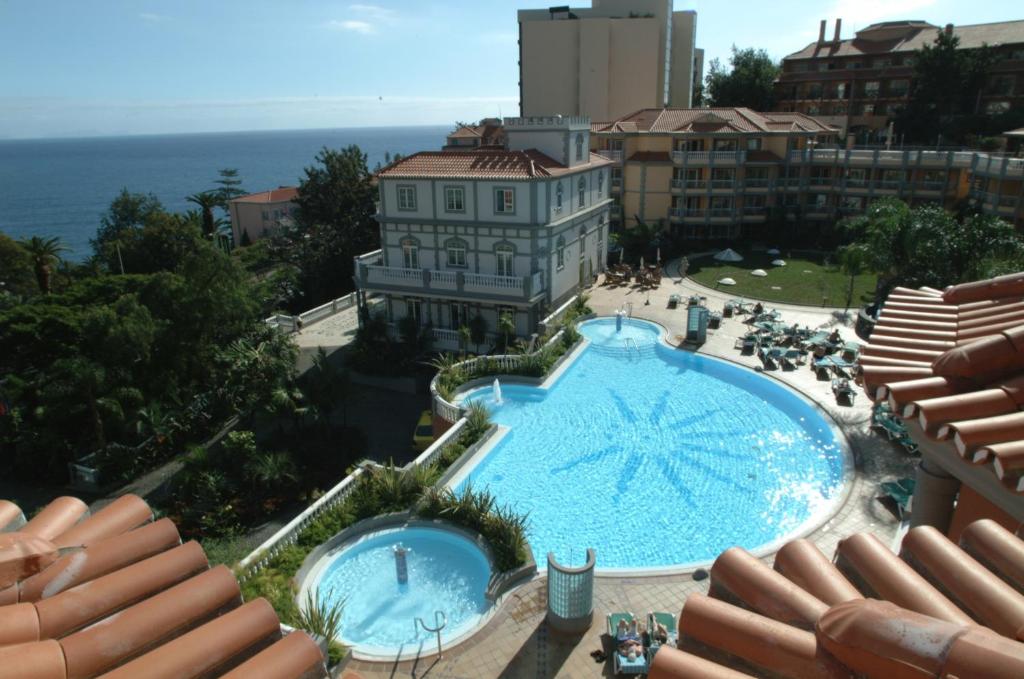 
a large swimming pool with a balcony overlooking the ocean at Pestana Miramar Garden & Ocean Hotel in Funchal
