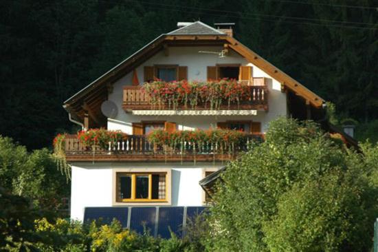 a house with a balcony with flowers on it at Haus Birke in Weissensee
