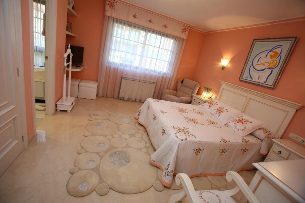 1 dormitorio con paredes de color naranja, 1 cama y 1 alfombra en Chalet Sameal Sanxenxo, en Sanxenxo