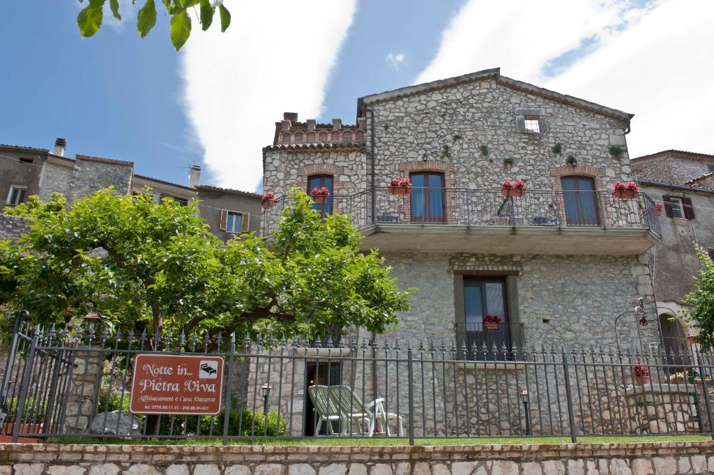 een oud stenen gebouw met een hek ervoor bij Holiday house "Pietra viva" in Castelnuovo Parano