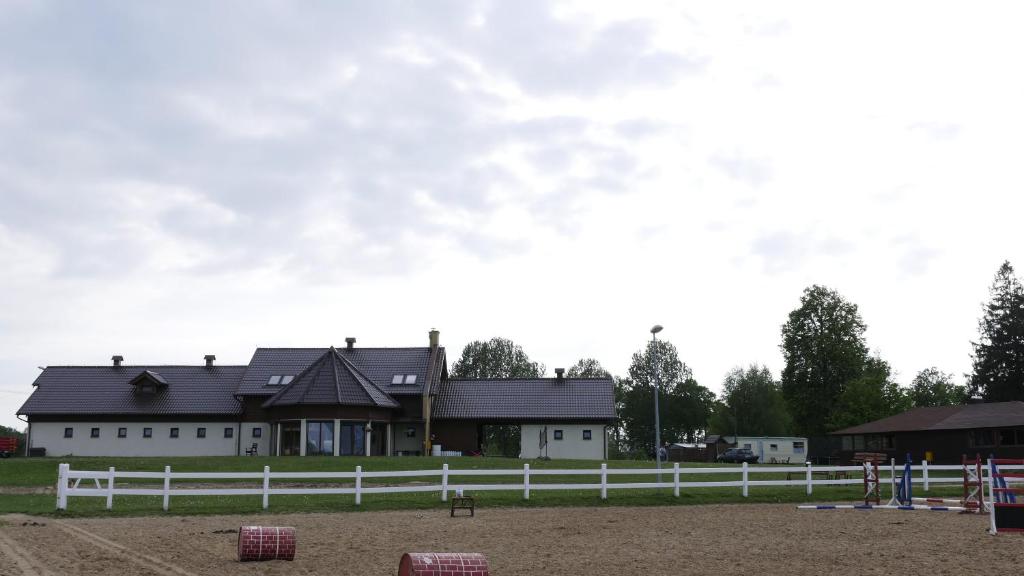 una recinzione bianca di fronte a un edificio bianco di Gospodarstwo Agroturystyczne Milejewko a Milejewo