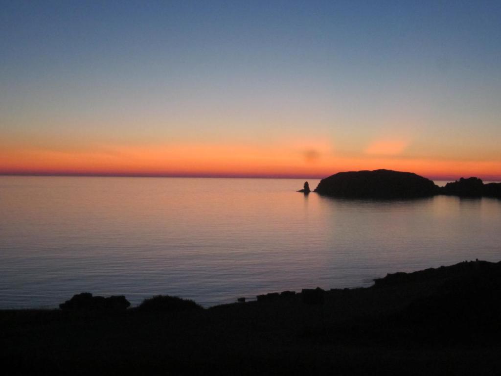 a person in a boat in the water at sunset at Casa Lugori in Torre Dei Corsari