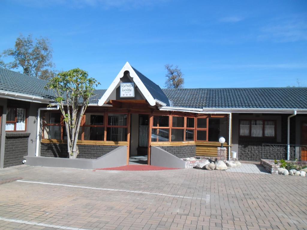 a building with a brick driveway in front of it at Reheifo Lodge in George