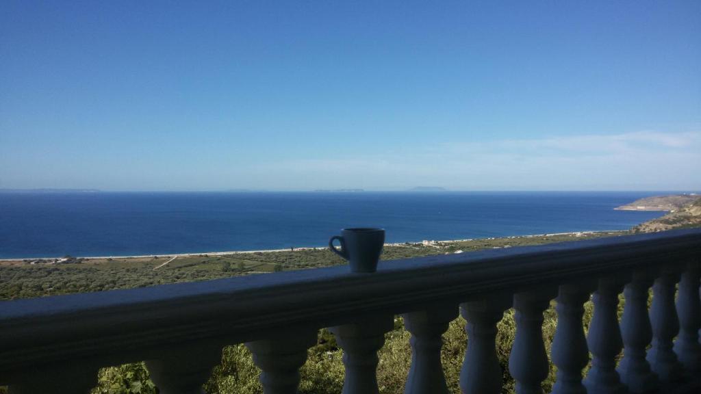 - une tasse de café assise sur un balcon donnant sur l'océan dans l'établissement OniRana Apartments, à Borsh