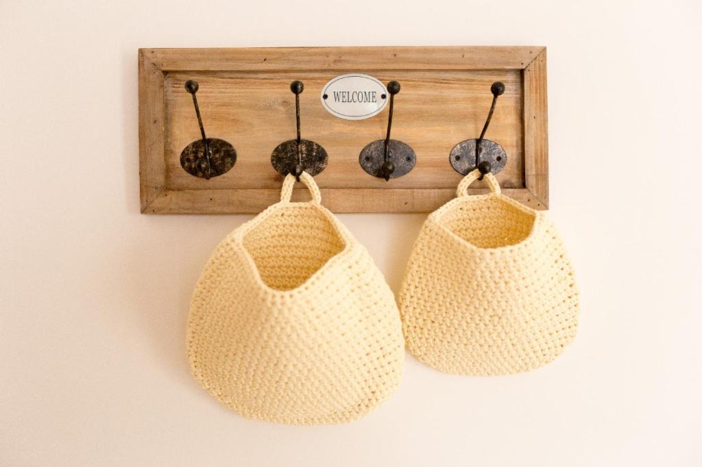 two crochet bags hanging on a wall with a wooden frame at la casa sul porto in Taranto