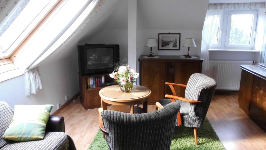 a living room with chairs and a table and a tv at Ferienwohnung mit Panoramablick in Kirchberg