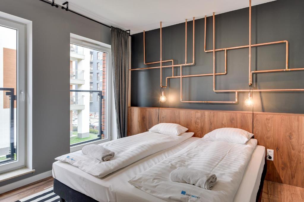 two beds in a room with a chandelier at Apartament Chmielna 1 in Gdańsk